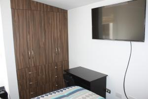 a bedroom with a bed and a tv on the wall at Terra Fecundis in Arequipa