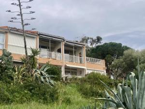 ein Haus auf einem Hügel mit Büschen und Bäumen in der Unterkunft Appartement Les marines du soleil in Patrimonio