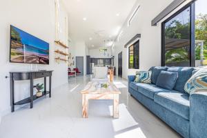 a living room with a blue couch and a table at CASA SERENITY , brand new house, walk 2 beach, private pool, wifi, PURA VIDA!!!! in Uvita