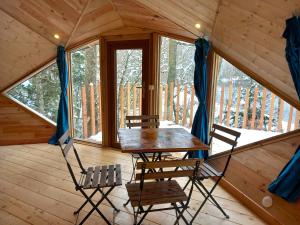 a table and chairs in a cabin with a window at Domaine du Balbuzard in Condat-en-Combraille