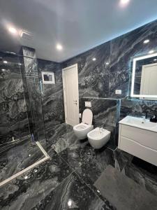a bathroom with a toilet and a sink and a shower at Skyline View Apartment in Ulcinj