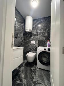 a bathroom with a toilet and a washing machine at Skyline View Apartment in Ulcinj