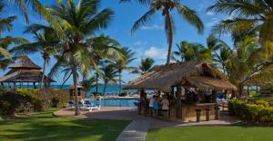 a group of people standing around a bar by a pool at Coconut Bay Beach Resort & Spa All Inclusive in Vieux Fort