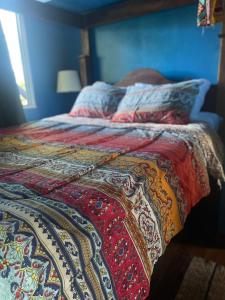 ベリーズシティにあるHowler Jungle Cabanas Belizeのベッド(カラフルな毛布付)