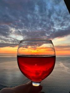a glass of wine with the sunset in the background at Grandview Batumi in Batumi +43 photos
