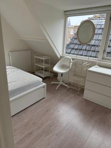 a bedroom with a bed and a mirror and a window at Casa Hofdijkstraat in Alkmaar