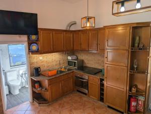 a kitchen with wooden cabinets and a microwave at Bela Vista in Paradela