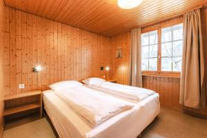 哈布凯恩Alphorn Chalet Habkern的卧室里有一张床，嵌在木墙里