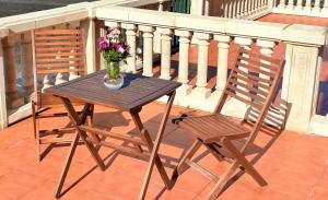 a table and a chair on a balcony with a vase of flowers at Apartamentos Luarca in Luarca