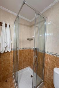 a shower with a glass door in a bathroom at Apartamentos Luarca in Luarca +15 photos