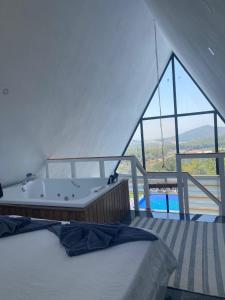 a bedroom with a bath tub and a large window at Villa Işık in Kas