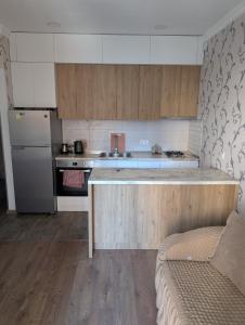 a kitchen with a counter top and a refrigerator at The Yellow Brick Apartment in Tbilisi City