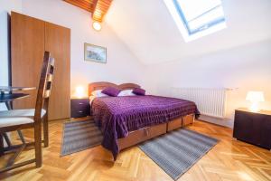 - une chambre avec un lit doté de draps violets et une fenêtre dans l'établissement Apartment Bastaja, à Slunj