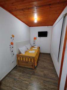 a small room with a bed and a flat screen tv at Cabañas a 5 minutos del río in Alta Gracia