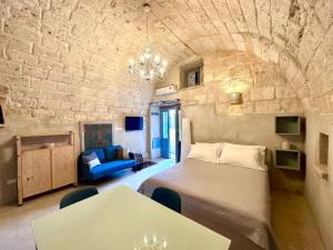 a bedroom with a bed and a couch and a table at Dimora di Leo in Bisceglie