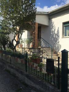 a fence in front of a house with potted plants at A casa di mamma in Rieti