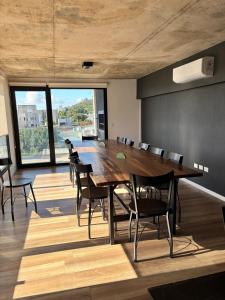 a conference room with a large wooden table and chairs at Moderno y luminoso departamento in Tandil +9 photos