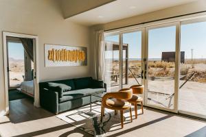 a living room with a green couch and chairs at Stardust Big Bend Luxury A-Frame#1 with a fab view in Terlingua