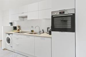 a white kitchen with a sink and a dishwasher at Fast Wifi I 4 min to U3 Zipperer Straße in Vienna