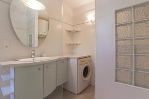ein Badezimmer mit Waschmaschine und Waschbecken in der Unterkunft Studio Marine du Soleil in Patrimonio
