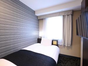 Postel nebo postele na pokoji v ubytování APA Hotel Kanda Ekihigashi