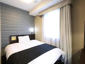 Postel nebo postele na pokoji v ubytování APA Hotel Kanda Ekihigashi