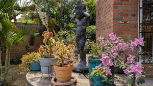 una estatua de una mujer parada junto a algunas plantas en Chalet Real, en Lemos