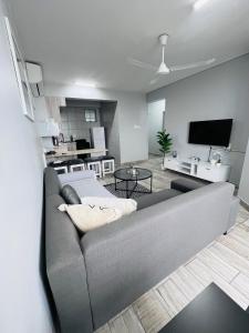 a living room with a gray couch and a tv at Ushaka Ocean Escape - Shaka Shores 5E in Durban