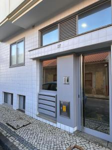 een wit bakstenen gebouw met een glazen deur bij Furadise Apartment in Ovar