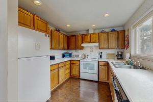 a kitchen with wooden cabinets and a white refrigerator at At The Seaside in Lincoln Beach
