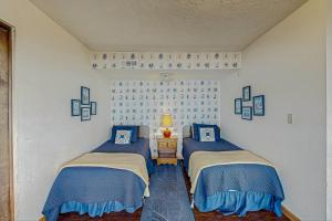 two twin beds in a room with a window at At The Seaside in Lincoln Beach