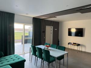 a dining room with a table and green chairs at 3 km to Legoland in Billund