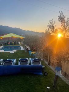 um quintal com cadeiras e uma piscina com o pôr do sol em Quinta do Sonho em Resende