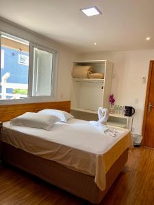 a large bed in a bedroom with a window at Casa Zanata in Gramado