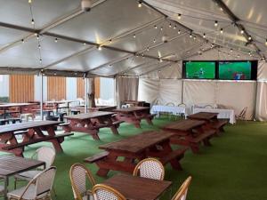 a tent with picnic tables and a screen in it at The Hampden Suites in Wagga Wagga