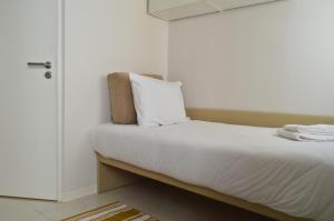 a bedroom with a bed with white sheets at Porta 4 in Nazaré