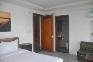 a bedroom with a bed and a chair and a door at Autumn Bay Retreat in Hoi An