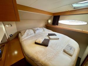 ein kleines Schlafzimmer mit zwei Handtüchern auf einem Bett in der Unterkunft Floatinn Boat-BnB in Genf