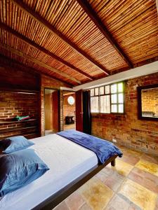 a bedroom with a large bed with a wooden ceiling at Santa Elena Ventanas Parapente Bed and Breakfast Premium in Santa Helena