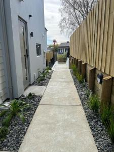 a sidewalk next to a fence next to a house at Apartment 4 on Armagh! in Christchurch