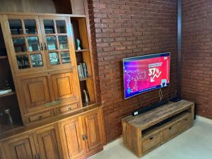 a flat screen tv sitting on a brick wall at Chácara Meu Pedaço Atibaia in Mairiporã