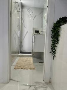 a white kitchen with a glass doorway with a rug at Mark Suite B8 in Fuengirola