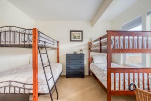 ロックアウェイ・ビーチにあるLakeside Haven - Meredith Lodgingのベッドルーム1室(二段ベッド2台、ドレッサー付)