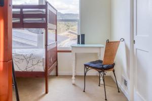 ロックアウェイ・ビーチにあるLakeside Haven - Meredith Lodgingのベッドルーム1室(二段ベッド1組、椅子、デスク付)