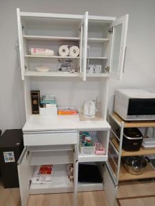 a kitchen with white shelves and a microwave at 花喜Usj in Osaka