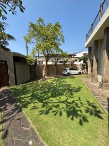 a shadow of a tree on the grass in a yard at Villa Plum Colombo in Battaramulla