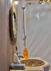 a bathroom sink with a shower and a mirror at Tudert Luxury Camp in Merzouga +36 photos