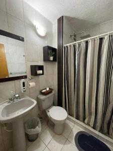 a bathroom with a toilet and a sink and a shower at Apartamento Maracay Base Aragua in Maracay +12 photos