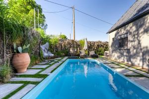 a swimming pool in the backyard of a house at Eros Elysium Retreat Villas in Kalavárda