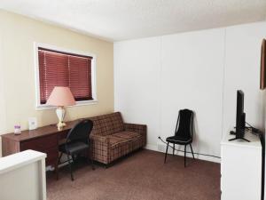 a living room with a couch and a desk and a television at Melsask Motel in Melville